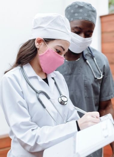 doctors wearing scrubs and gowns made by custom workwears in white and grey color